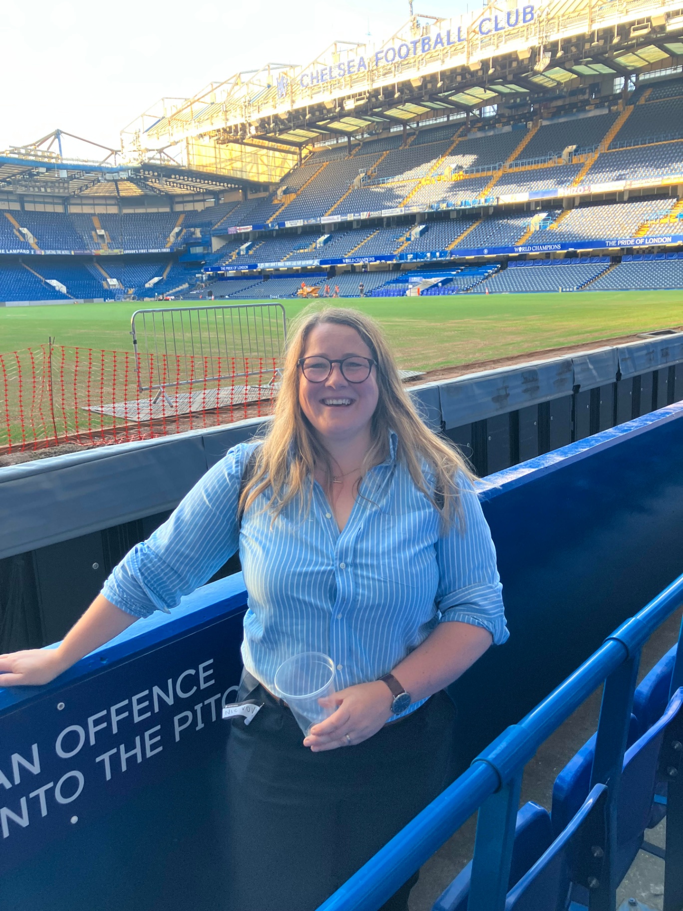 Nic, founder of Nettie, pitchside at Stamford Bridge wearing a Nettie top